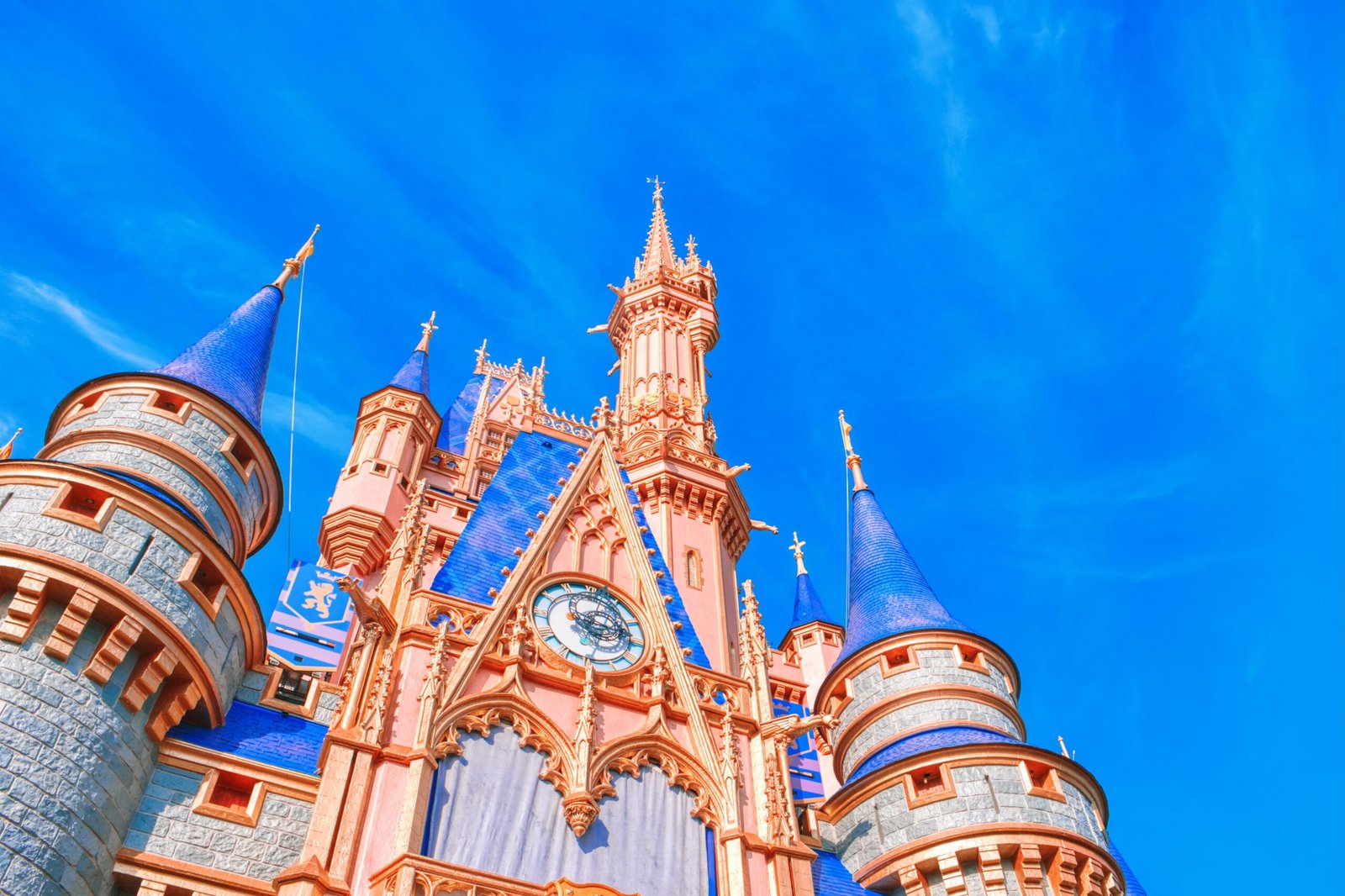 a pink and blue castle with a clock